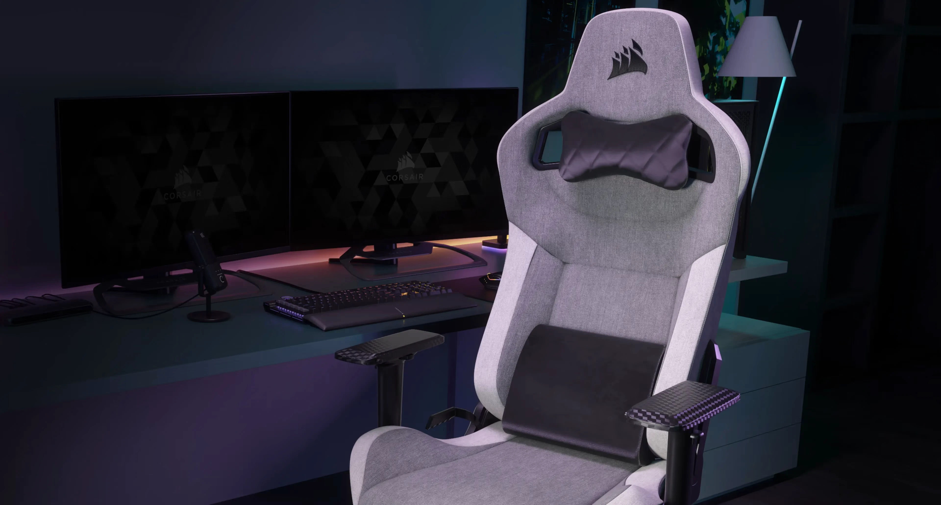 Siège gaming Corsair ergonomique gris avec soutien lombaire dans un setup gaming