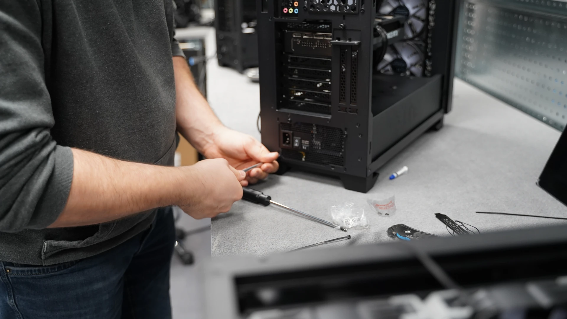 PC compact noir avec panneau avant en bois à côté d'un moniteur